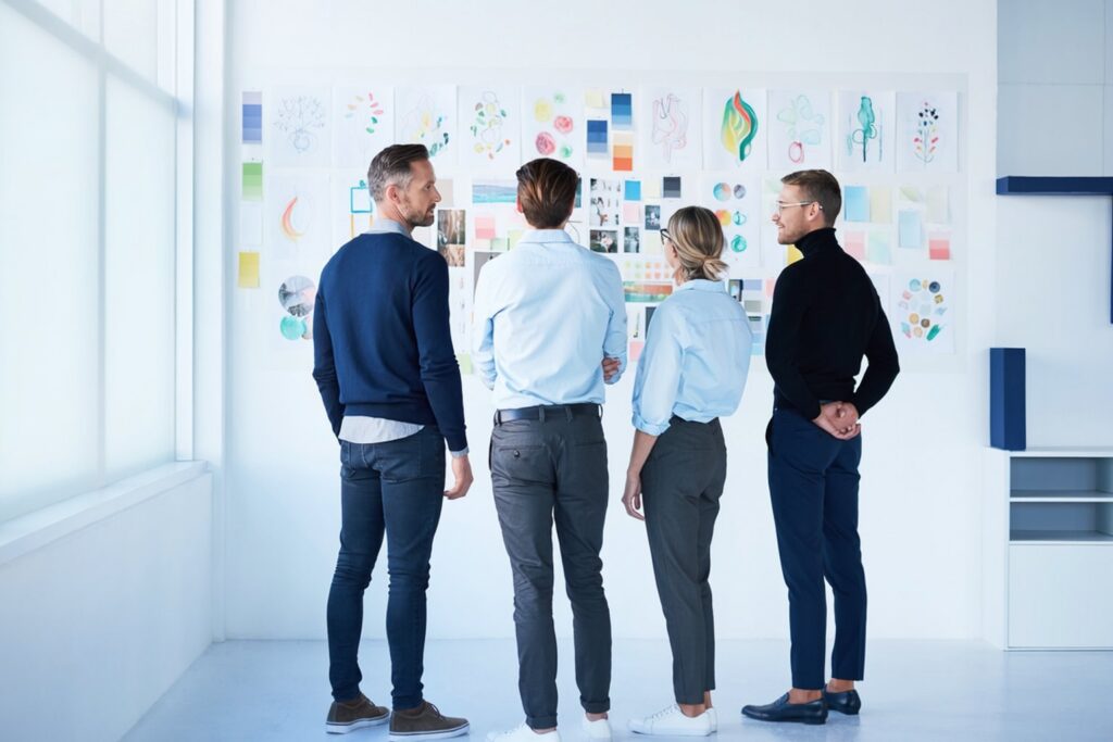 Creative team in front of a wall of storyboards and a mood board